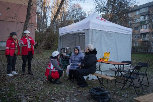 Paramedics give psychological aid to residents of a damaged apartment building following a Russian drone attack in Kyiv, Ukraine, Saturday, Nov. 25, 2023.