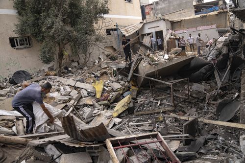 Palestinesi ispezionano le macerie di una casa dopo che è stata bombardata da un attacco aereo israeliano a Khan Yunis, nel sud della Striscia di Gaza, venerdì 27 ottobre 2023. 