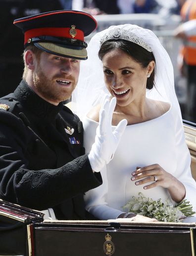 Meghan Markle reacts as she rides in a carriage with her husband Britain's Prince Harry after their wedding ceremony at St. George's Chapel in Windsor Castle in Windsor, near London, England, Saturday, May 19, 2018