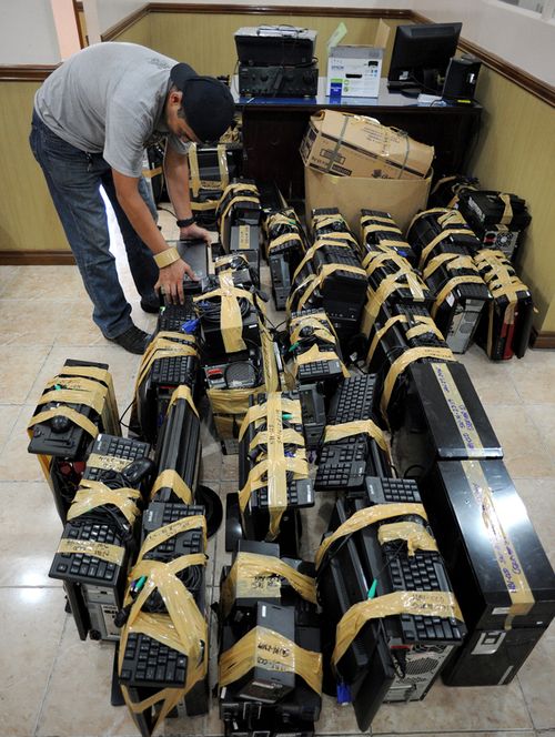 A National Bureau of Investigation (NBI) agent inspects confiscated desktop computers allegedly used for cybersex crime,