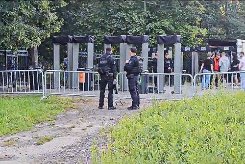 In this photo taken from video, police officers stand in front of the closed area of the Porokhovskoye cemetery after a memorial service for mercenary chief Yevgeny Prigozhin, who was killed in a plane crash last week, in St. Petersburg, Russia, Tuesday, Aug. 29, 2023.  