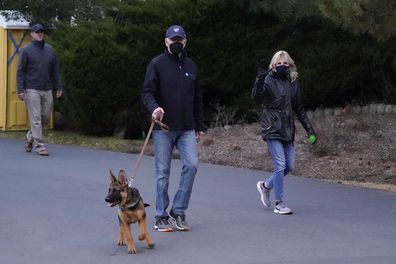 President Joe Biden and first lady Jill Biden take their dog Commander for a walk in Rehoboth Beach, Del., Tuesday, Dec. 28, 2021. (AP Photo/Patrick Semansky)