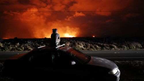 Brittany Kimball watches as lava erupts from from a fissure near Pahoa, Hawaii, Saturday, May 19, 2018. (AP)