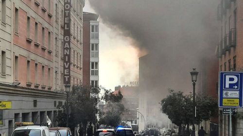 Sale humo de un edificio y escombros esparcidos en la calle Toledo luego de una explosión en el centro de Madrid, España, el miércoles 20 de enero de 2021.