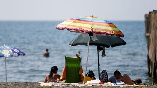 People enjoy a day at the beach, in Ostia, in the outskirts of Rome, Saturday, Aug. 14, 2021.  (Cecilia Fabiano/LaPresse via AP)