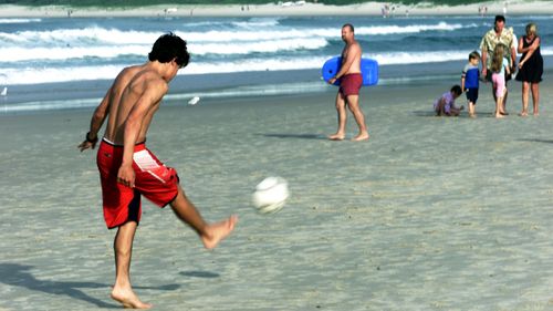 Tourists on Byron Bay beach, in New South Wales. Popular holidays spots across the state have been struggling since the coronavirus followed deadly bushfires.