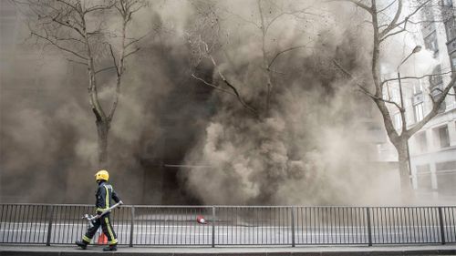 A fireman walks down Kingsway as smoke rises from the underground cable fire. (AAP)
