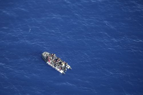 In this handout photo released by German non-governmental organisation Sea-Watch on Tuesday, Oct. 25, 2022, migrants attempting to cross the Mediterranean Sea on a rubber boat to Europe are seen during an interception by a Libyan coast guard ship in international waters. (Fiona Alihosi/Sea-Watch via AP)