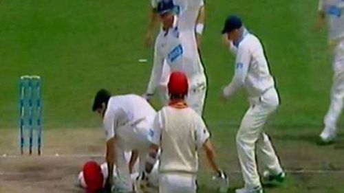 Players rush to Hughes' assistance after he collapses on the field. (Supplied)