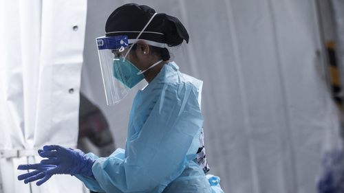 A health worker prepares to carry out COVID-19 testings out at a drive-through clinic (file photo).