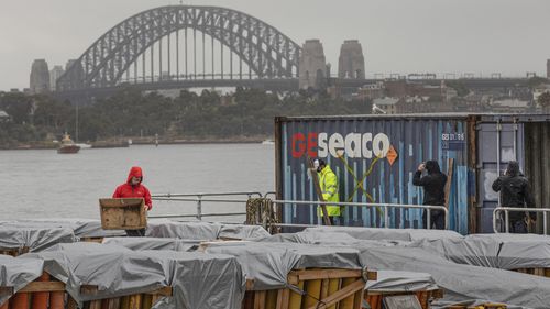 Foti International Fireworks workers ready a barge filled with fireworks for the 2021 NYE fireworks display at Glebe Island in Sydney on Wednesday, December 29, 2021. Photo by Cole Bennetts.