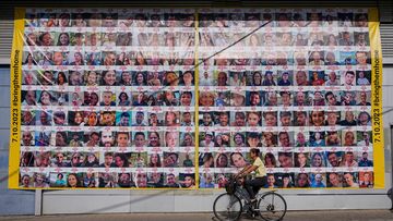 A woman cycles next to a billboard calling for the return of about 240 hostages who were abducted during the Oct. 7, Hamas attack on Israel. in Tel Aviv, Israel on Friday, Nov. 24, 2023.