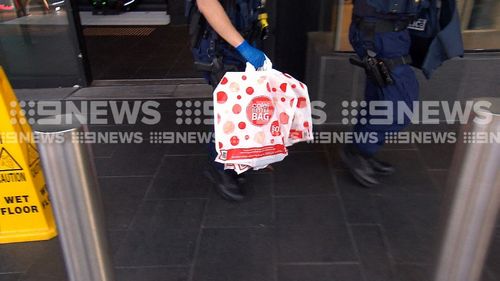 Evidence seized from the scene of the arrests was taken away by police in a Coles shopping bag.