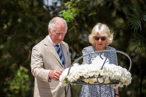 Prince Charles and Camilla, Duchess of Cornwall, observe a wreath next to mass graves at the Kigali Genocide Memorial in the capital, Kigali, Rwanda, on Wednesday, June 22, 2022. 