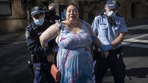 A woman is arrested  outside the Parliament of New South Wales in Sydney.