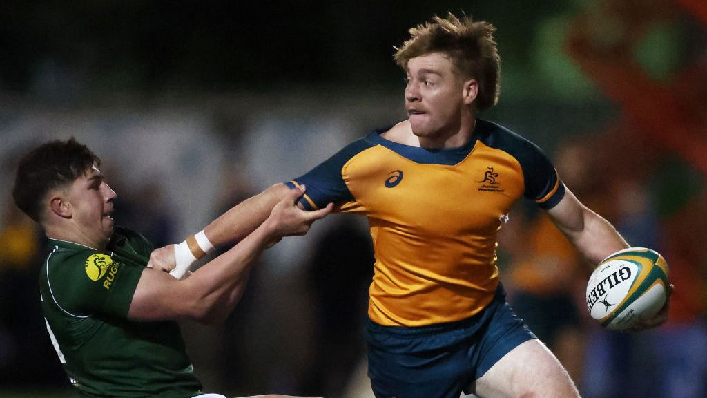 Harry McLaughlin-Phillips of the Junior Wallabies is tackled at David Phillips Field.