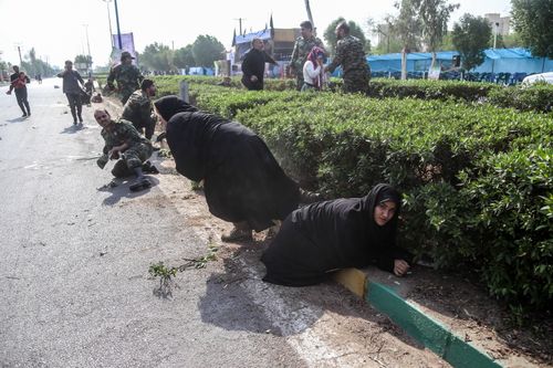 Iranian soldiers, women, and children lay down and run during a terror attack that occurred at military parade in the city of Ahvaz, southern Iran. (AAP)