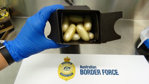 Officers allegedly found around 4.7kg of cocaine hidden in chocolate and alcohol boxes. (Australian Federal Police)
