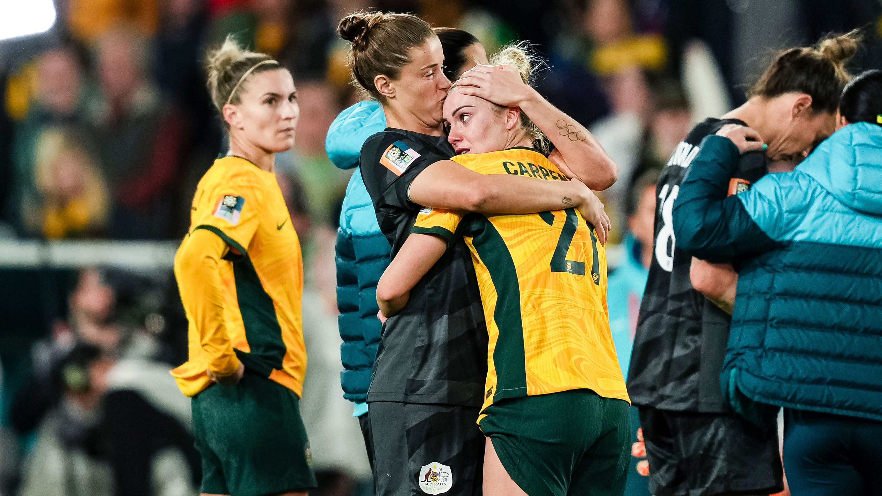 Dejected Matildas star Ellie Carpenter is comforted after Australia&#x27;s World Cup semi final loss to England.
