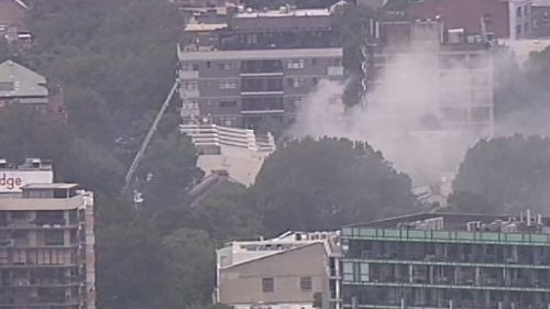 Fire crews use ladders to rescue two people from burning terrace in Surry Hills, Sydney