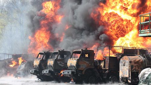 Trucks on fire after missiles struck an oil depot in a region of Ukraine controlled by Russian-backed separatists.