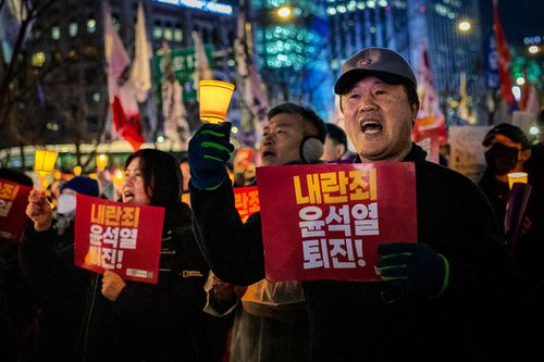 Protesters march towards the presidential office after a candlelight vigil against South Korean President Yoon Suk-yeol in Seoul, South Korea, Thursday, Dec. 5, 2024.