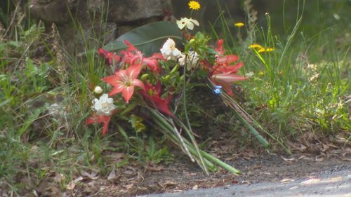 Flowers left by the house where twins were killed in a fire near Byron Bay, NSW.