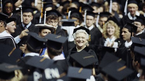 Mrs Bush is remembered as a fierce literacy advocate. She is pictured with graduates at St Louis University in 1990. (AAP)