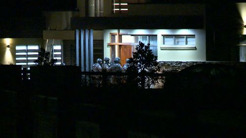 Heavily armed police approach the home. (9NEWS)