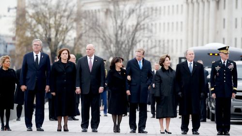 From right to left: former President George W. Bush, former first lady Laura Bush, Neil Bush, Sharon Bush, Bobby Koch, Doro Koch, Jeb Bush and Columba Bush, watch as former President George H.W. Bush is carried by a joint services military honour guard from the Capitol.