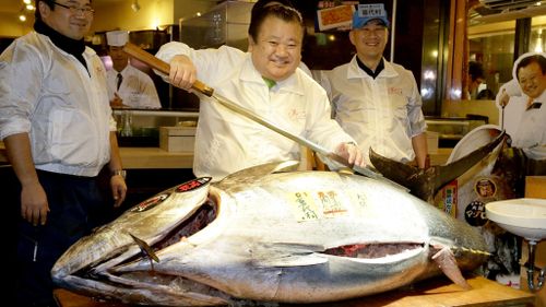 Kiyoshi Kimura, chief of a sushi restaurant chain, shows off the 200-kilogram bluefin tuna. (AP)