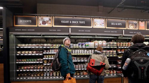 A customer looks overhead in an Amazon Go store, where sensors and cameras are part of a system used to tell what people have purchased and charge their Amazon account. (AAP)
