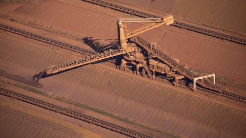 An iron ore stacker feeds stockpiles at Rio Tinto iron ore mine site in the Pilbara region of Western Australia.