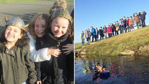 School children farewell class goldfish with fiery Viking boat burial