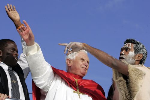 Pope Benedict XVI, centre, talks to an Australian Aborigine while waving to pilgrims aboard a harbor cruise in Sydney, Australia, on July 17, 2008.