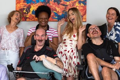 Margot Robbie poses with Aussies who rely on Youngcare, their families and carers.
