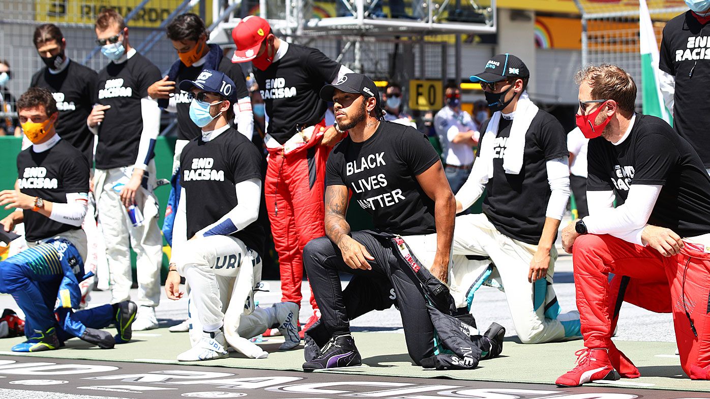 Lewis Hamilton of Great Britain and Mercedes GP and some of the F1 drivers take a knee on the grid in support of the Black Lives Matter movement 