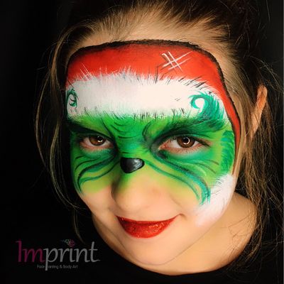 A bright red lip complements this festive face paint