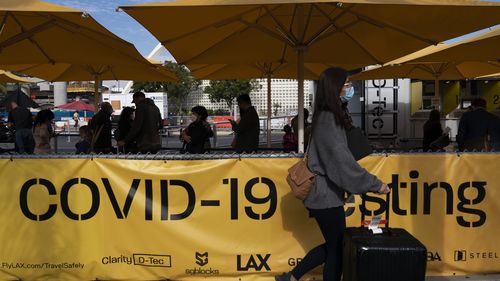 Travellers wait in line to get tested for COVID-19 at Los Angeles International Airport in Los Angeles.