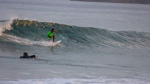 Chris Hasson took a photograph of his son riding a wave without realising the shark was there. (Facebook/Chris Hasson)