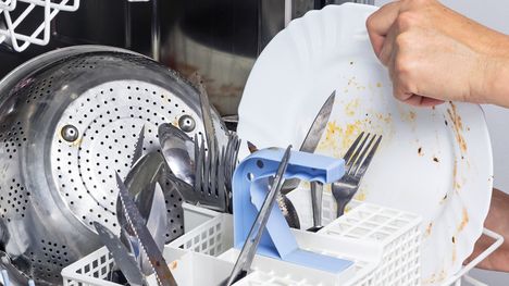 Woman putting dirty dishes in a dishwasher