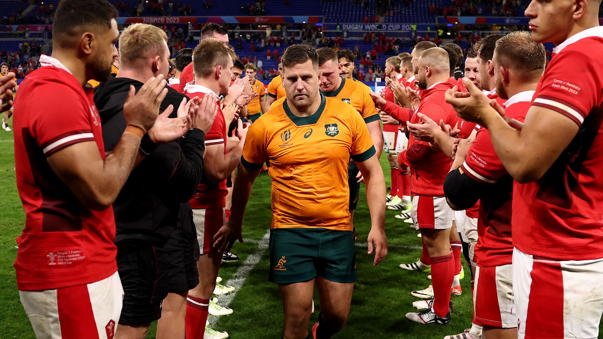 The players of Wales give the players of Australia a guard of honour as they leave the pitch at full-time.