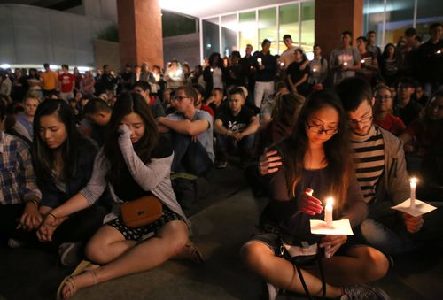 Student mourners console each other during a candlelight vigil at the University of Nevada Las Vegas. (AAP)