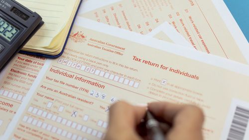 Generic picture of someone filling out a tax return.