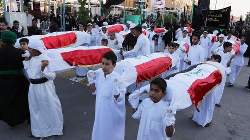 Muslim worshippers carrying coffins of ISIL victims. (AAP) 