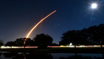 In this image taken with a slow shutter speed, a SpaceX Falcon 9 rocket from Launch Pad 39A at Kennedy Space Center, arcs across the night sky in January 2022. The rocket carried 49 Starlink internet satellites.