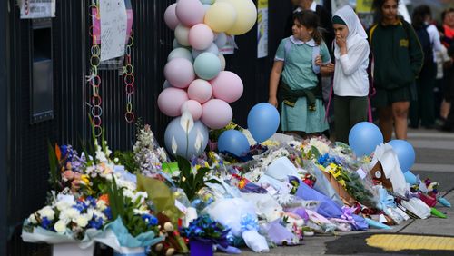 Balloons and flowers are laid as tributes outside the school.