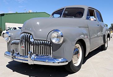 By what designation was the first Holden-badged vehicle, 48-215, unofficially known?