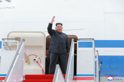 North Korean leader Kim Jong Un, center, waves as he leaves for Singapore, at Pyongyang international airport 