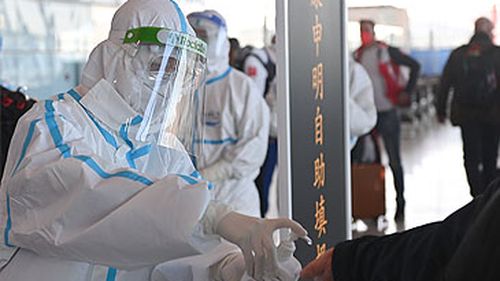 Oficial aplicando desinfetante para as mãos no Aeroporto Internacional Capital de Pequim (Getty)